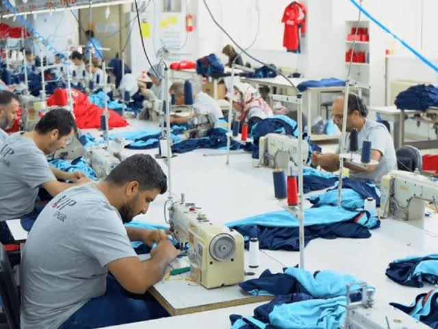 Workers at industrial sewing machines during garment production