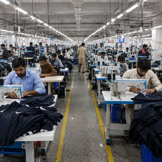 Workers at sewing stations during bulk garment production